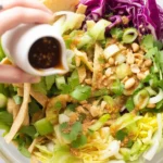 Colorful Asian salad with cabbage and sesame dressing, showcasing vibrant ingredients.