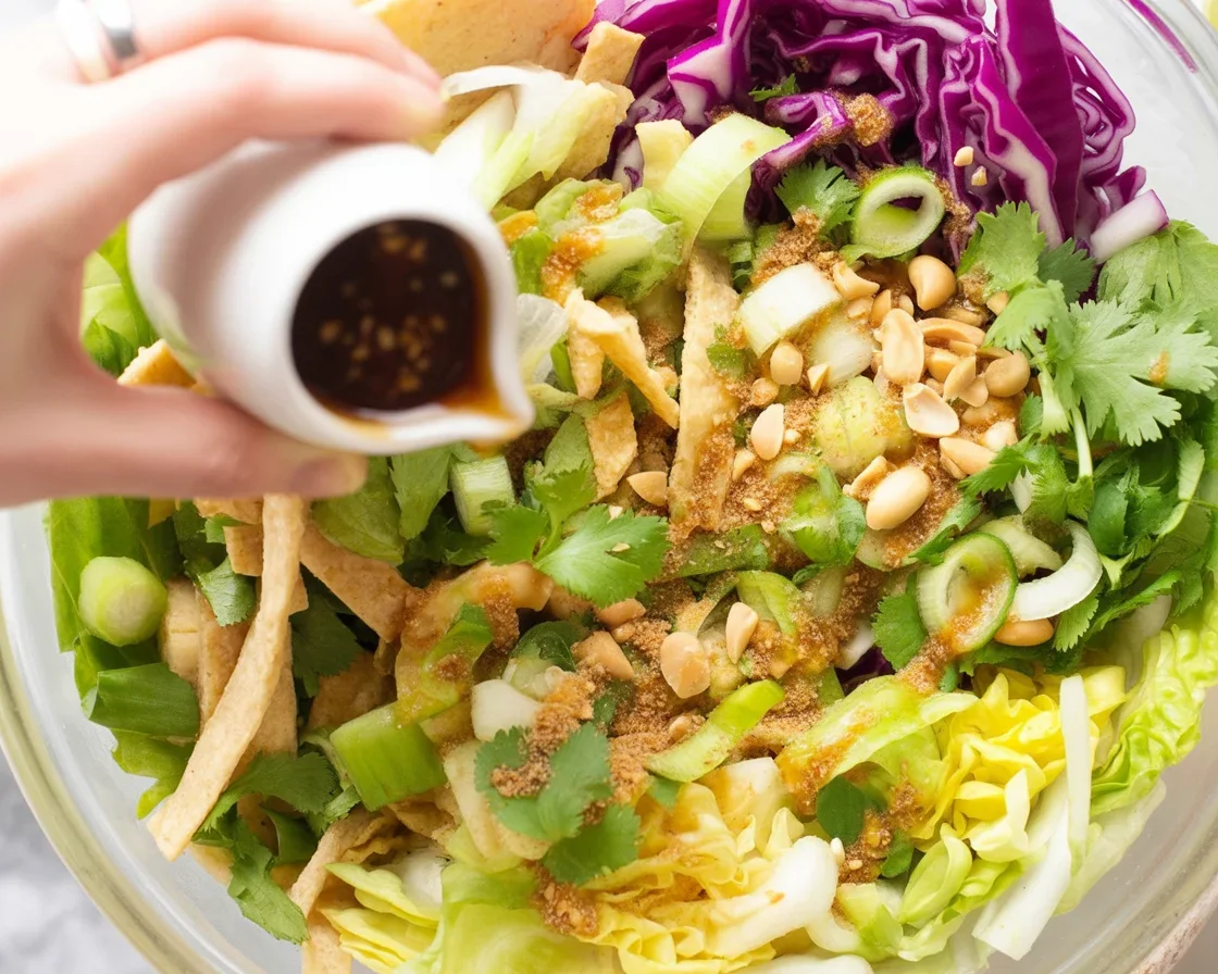 Colorful Asian salad with cabbage and sesame dressing, showcasing vibrant ingredients.