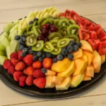 A colorful and fresh fruit platter featuring strawberries, watermelon, and grapes.