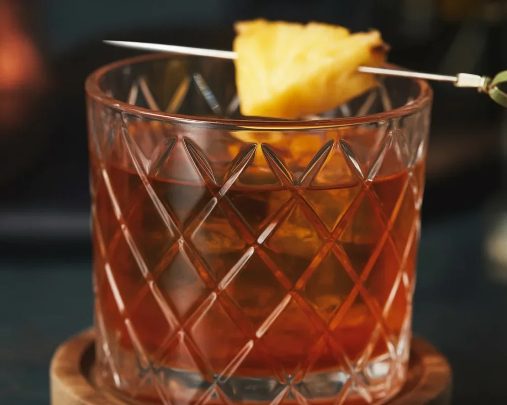 A refreshing Pineapple Old Fashioned cocktail with bourbon and pineapple garnish.