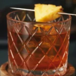 A refreshing Pineapple Old Fashioned cocktail with bourbon and pineapple garnish.